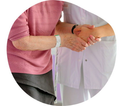 Une patiente tient la main d'une soignante afin de garder l'équilibre.